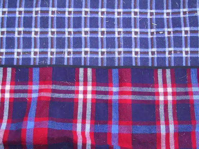 Two folded plaid wool cloths, a blue and white check above a red, navy and white tartan.